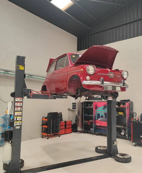 Roter Oldtimer Fiat 600 auf der Hebebühne